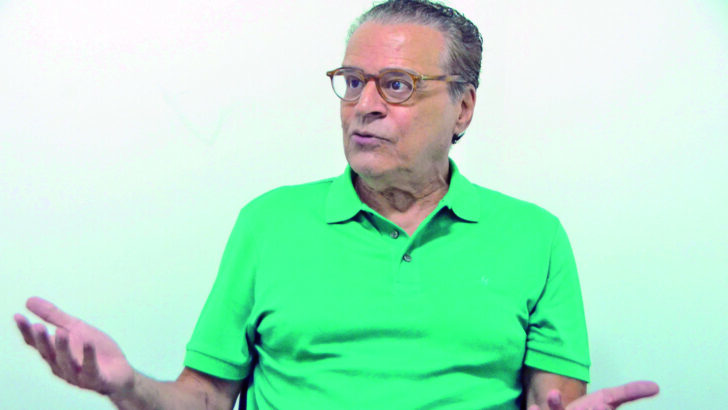Henrique Eduardo Alves, de óculos e camisa polo verde, gesticula com as mãos durante entrevista