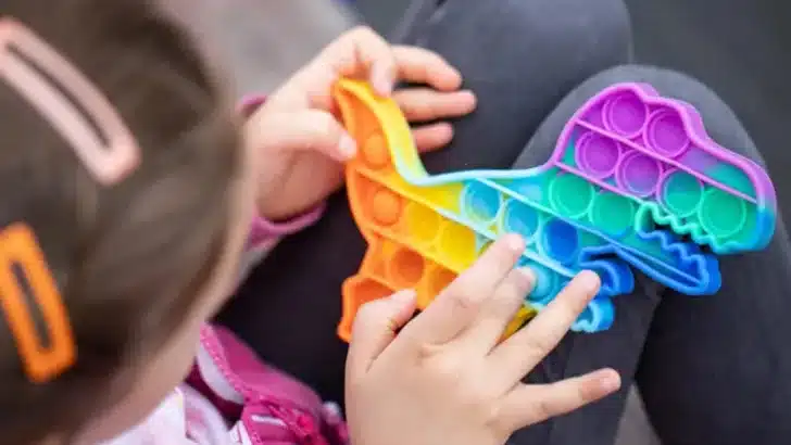 popular colorful anti stress touch toy dragon shaped fidgets push pop it in the hands of a child 768x525
