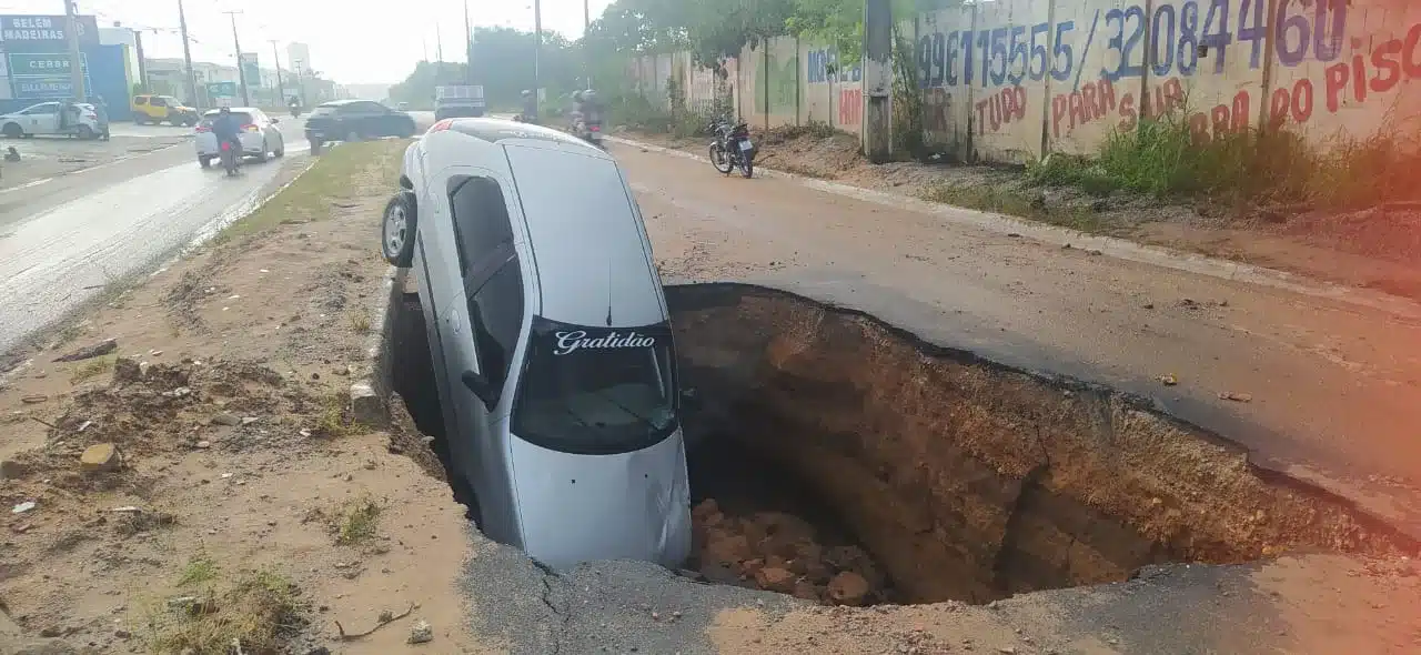 Asfalto cede e carro cai em cratera na avenida Olavo Montenegro