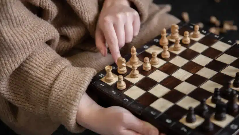 Torneio de xadrez vai comemorar 50 anos do bairro de candelária | notícias do rio grande do norte Woman placing chess pieces on a chessboard.