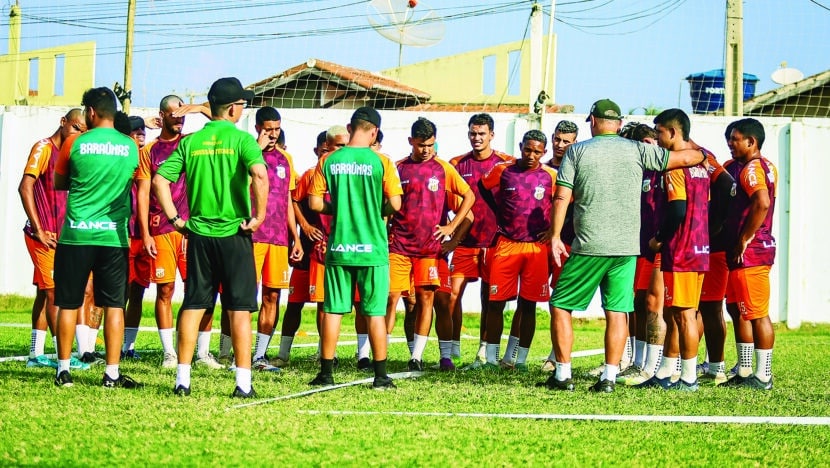 Jogadores do Baraúnas reunidos em roda com a comissão técnica no gramado durante treino