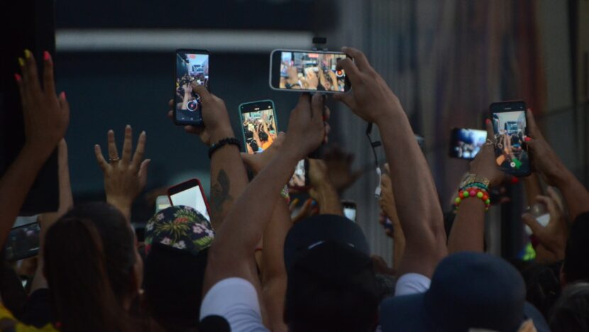 Pessoas seguram celulares para registrar um evento