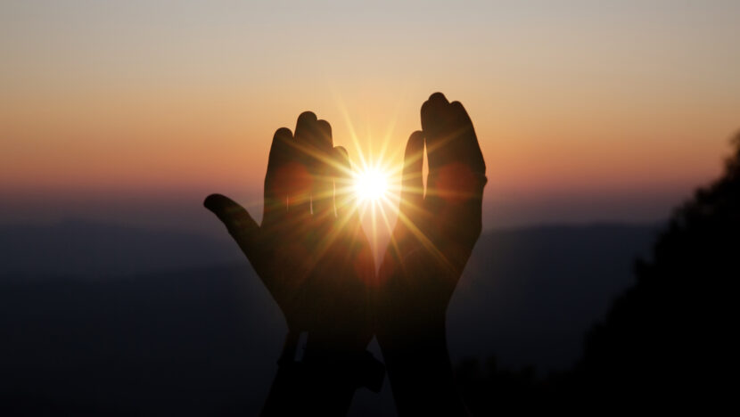 Faith of christian concept: Spiritual prayer hands over sun shin