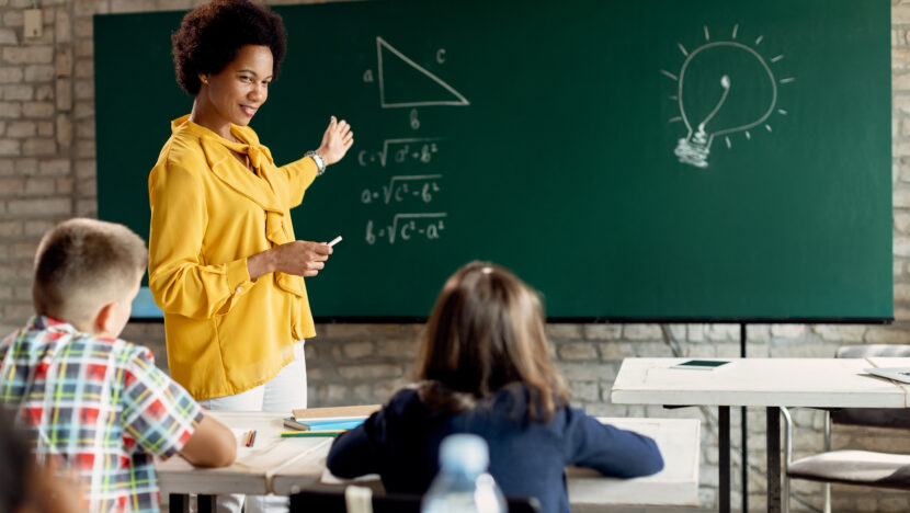 feliz professor negro ensinando matematica de alunos ensino fundamental na sala de aula