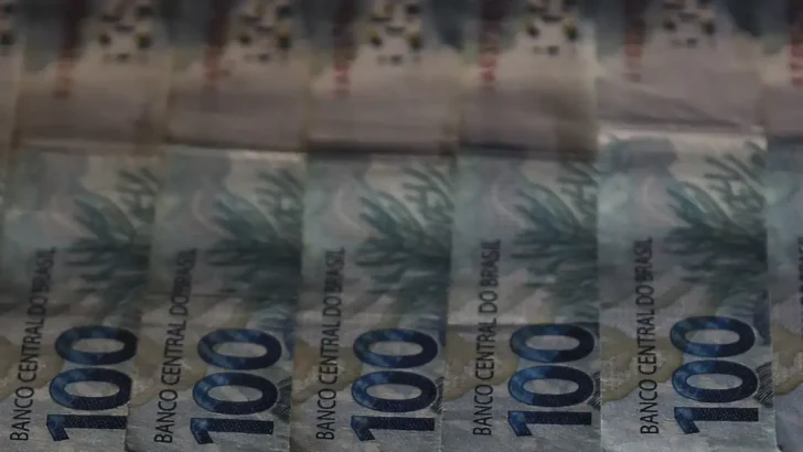 Cédulas e moedas de real ilustram debate sobre a reforma tributária