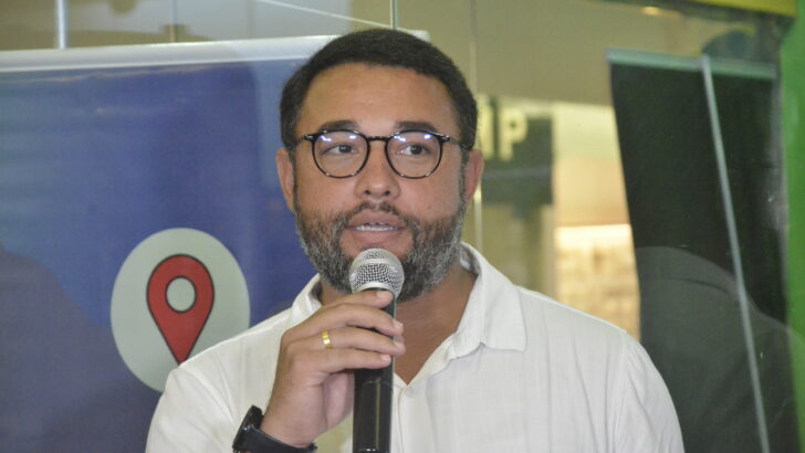 Matheus Feitosa de óculos, falando ao microfone, em imagem de arquivo
