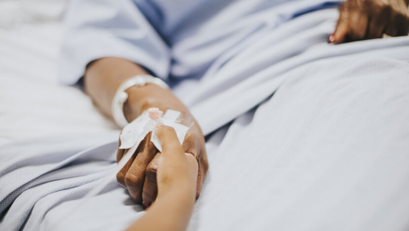 daughter holding her mothers hand hospital