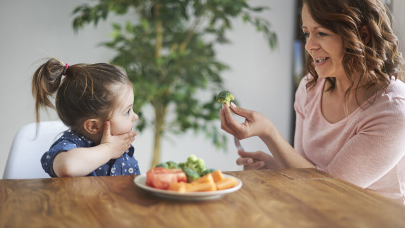 little girl eating vegetables