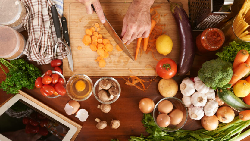 top view cropped hands senior cook unrecognizable cutting carrot cooking vegetable stew