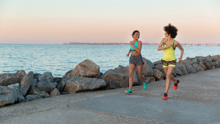 two young sportswomen running together talking