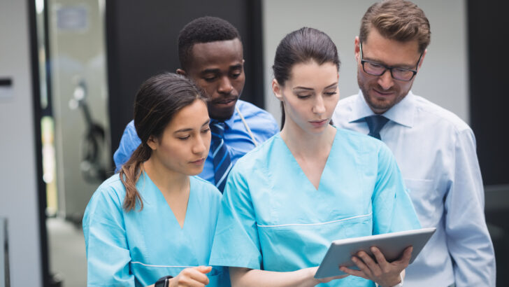 medical team discussing digital tablet