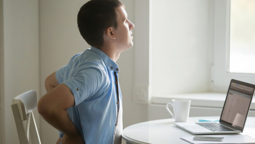 profile portrait man laptop stretching backache position