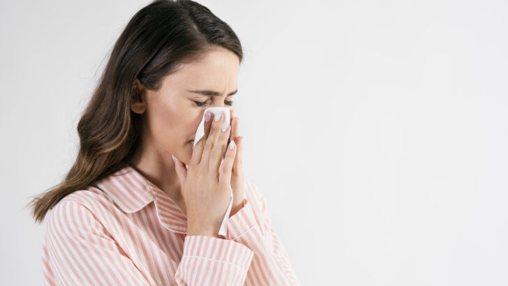 young woman blowing her nose