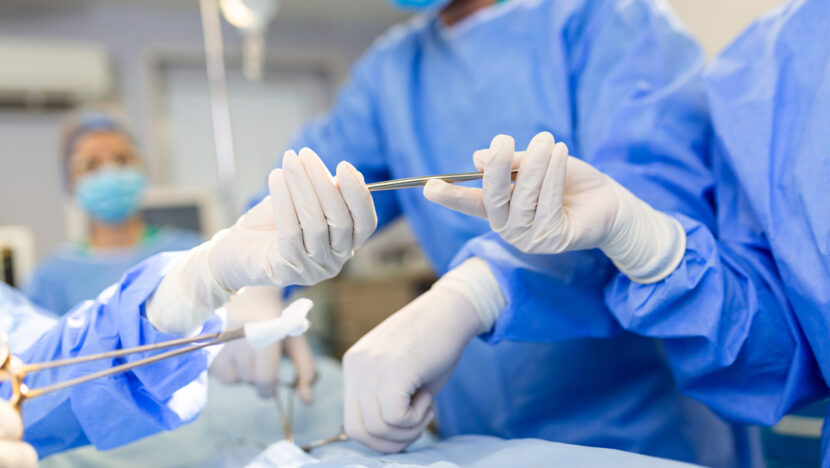 low angle shot operating room assistant hands out instruments surgeons operation surgeons perform operation professional medical doctors performing surgery
