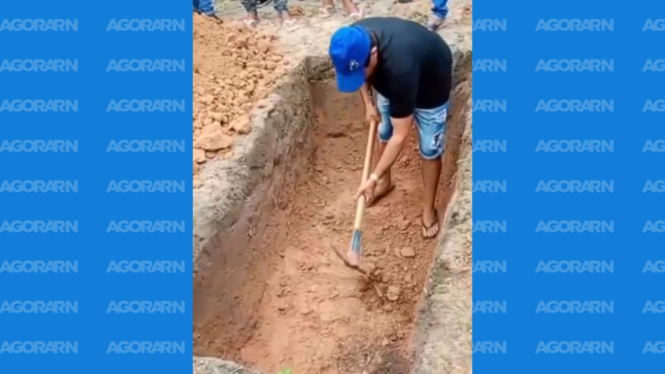 Familiares utilizam ferramentas para concluir a abertura de uma cova durante sepultamento no Cemitério Municipal do Mendes, em São José de Mipibu