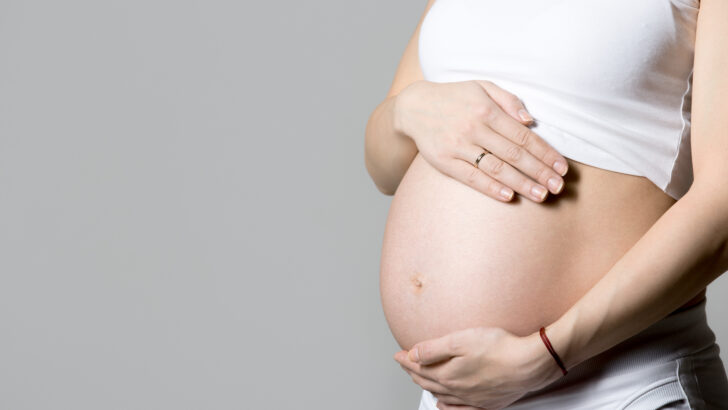 pregnant woman touching her belly Copia