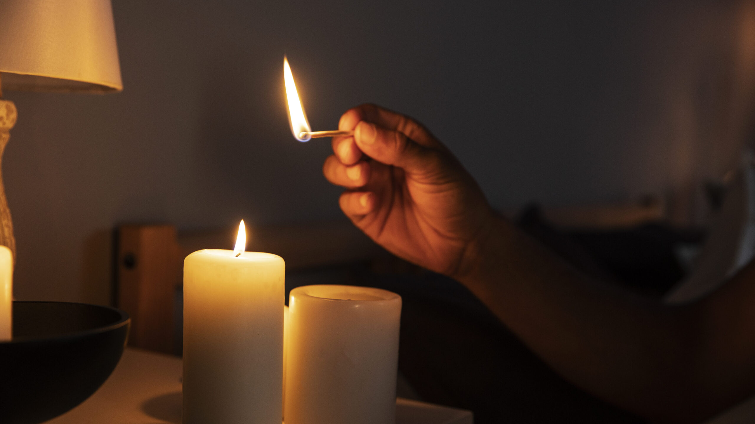 side view hand lighting candle