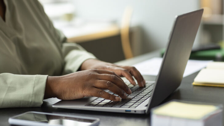 side view worker typing laptop