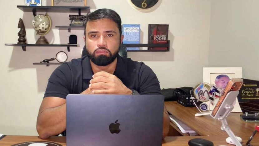 Jornalista Luís Pablo sentado diante de um computador em ambiente de trabalho