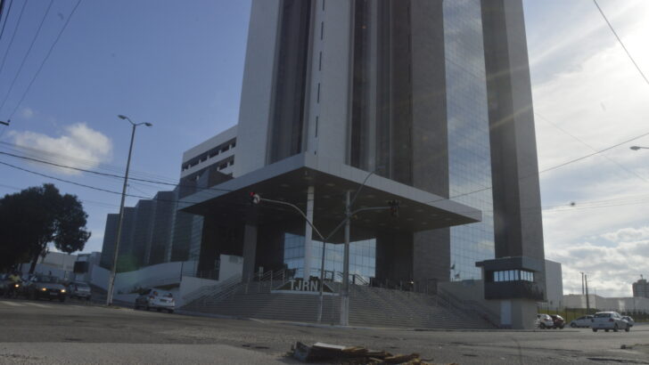 Fachada do prédio do Tribunal de Justiça do Rio Grande do Norte, com escadaria de acesso e veículos circulando pela via em frente à sede