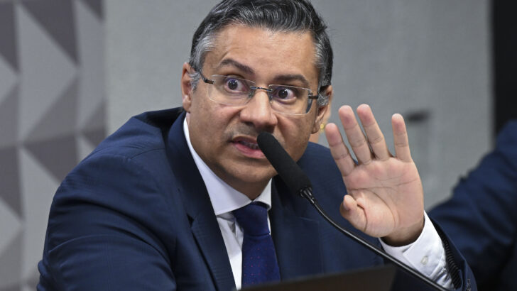 Virgílio Oliveira durante participação em audiência, sentado diante de um microfone