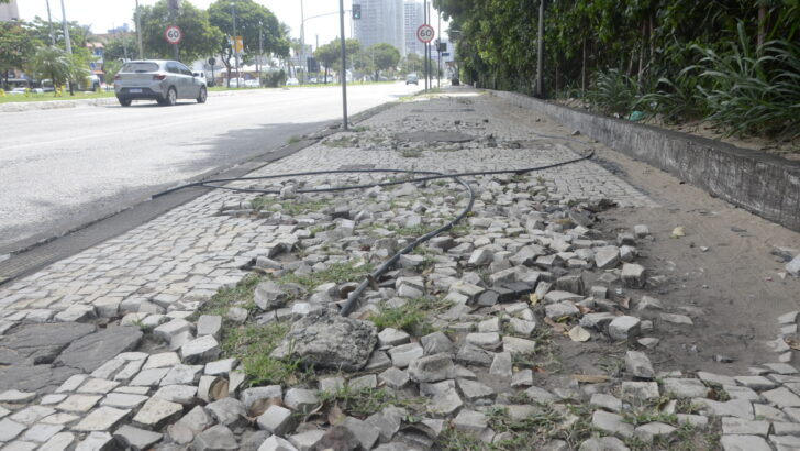 Calçada com pedras soltas e trechos danificados ao longo da Avenida Engenheiro Roberto Freire, em Natal