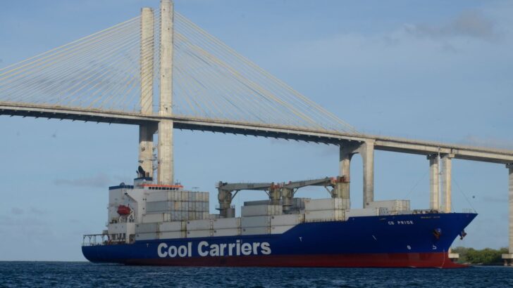Navio de carga com contêineres navega sob a Ponte Newton Navarro, em Natal.