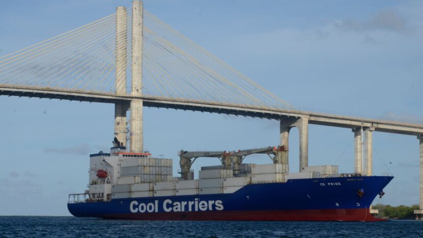 Navio de carga com contêineres navega sob a Ponte Newton Navarro, em Natal.