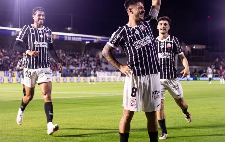 Rodrigo Garro comemora com o braço erguido ao lado de jogadores do Corinthians durante partida