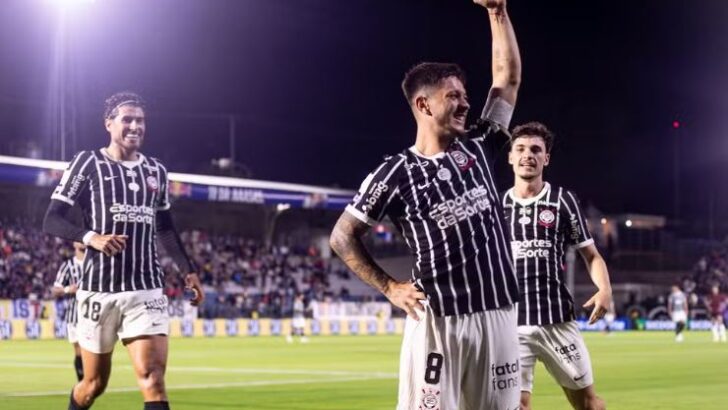 Rodrigo Garro comemora com o braço erguido ao lado de jogadores do Corinthians durante partida