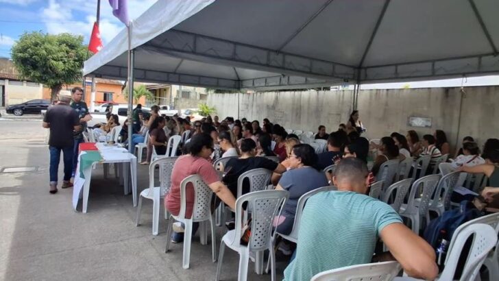 Trabalhadores reunidos em cadeiras sob uma tenda durante mobilização de servidores da saúde
