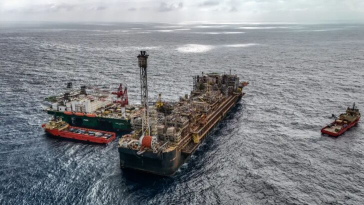 Estrutura de produção de petróleo em alto-mar aparece cercada por embarcações de apoio
