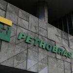 Fachada de um edifício da Petrobras, com o logotipo verde e amarelo da empresa fixado em uma parede de concreto