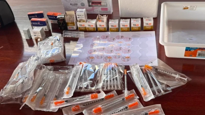 Caixas de medicamentos, produtos injetáveis e diversas seringas embaladas dispostas sobre uma mesa