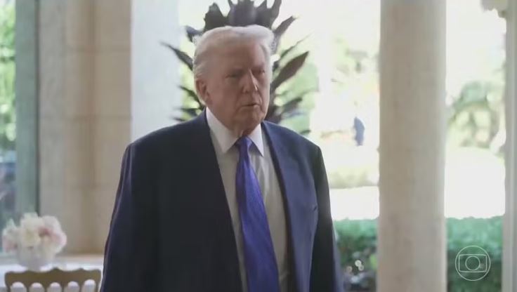 Donald Trump usando terno escuro e gravata em ambiente interno
