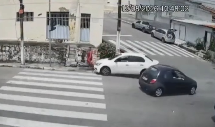 Imagem de câmera de segurança mostra dois carros no cruzamento e uma mulher próxima à calçada no bairro das Quintas, em Natal