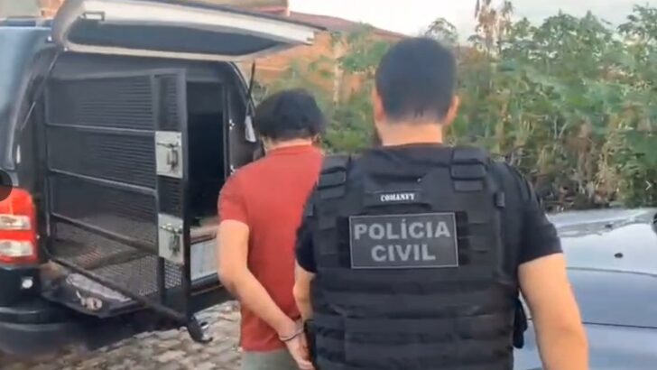 Policial civil acompanha homem algemado em direção a uma viatura durante cumprimento de mandado de prisão