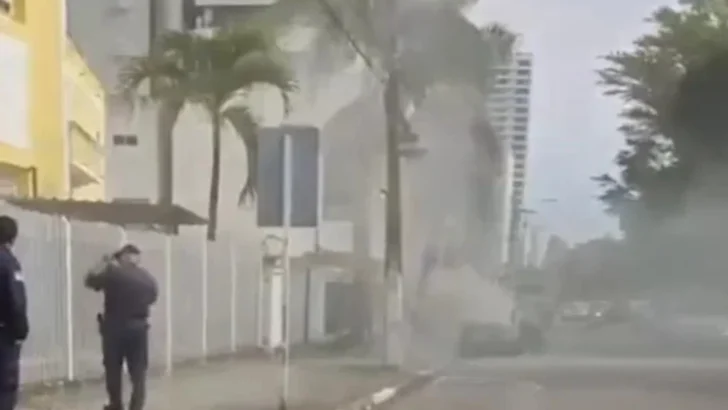 Rua com grande quantidade de fumaça e pessoas na calçada durante ocorrência envolvendo um veículo em Natal