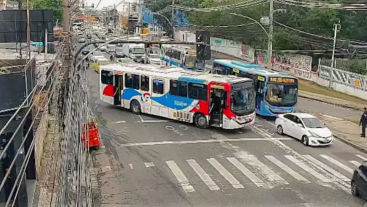 Ônibus aparecem atravessados em uma avenida, bloqueando parte da circulação de veículos