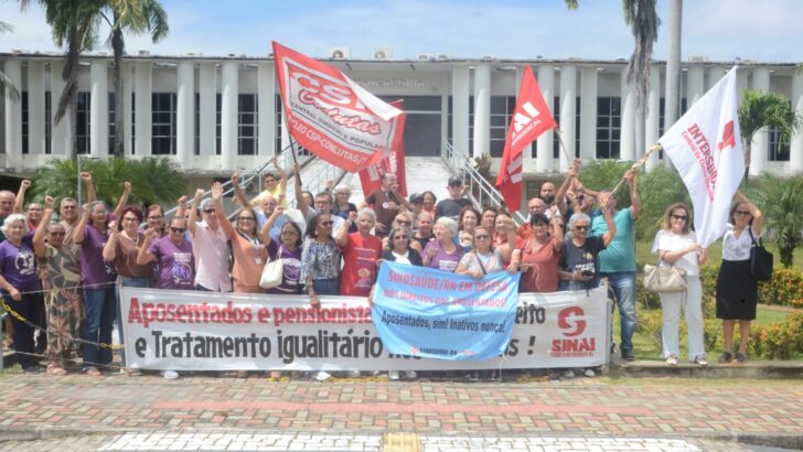 Manifestantes exibem uma faixa durante protesto de aposentados e pensionistas na rampa da GoveRio Grande do Norteadoria do Rio Grande do Norte