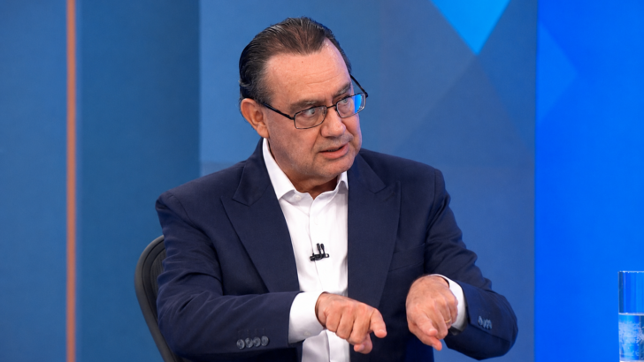 Augusto Cury sentado em bancada de estúdio de televisão durante entrevista