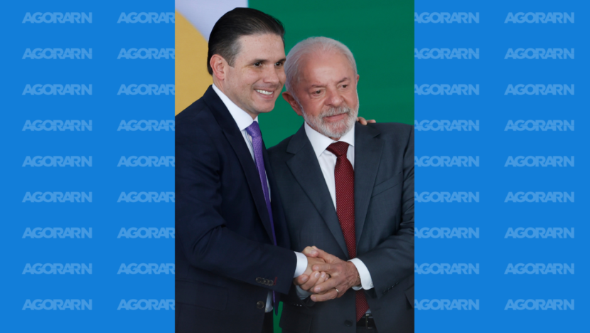 Hugo Motta e o presidente Lula aparecem lado a lado, de terno, durante cerimônia