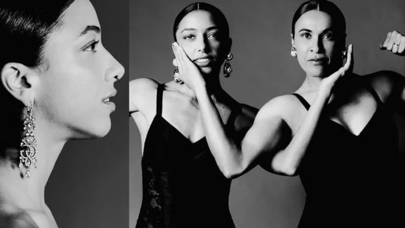 Duas mulheres posam lado a lado em fotografia em preto e branco, usando roupas pretas e fazendo poses com os braços