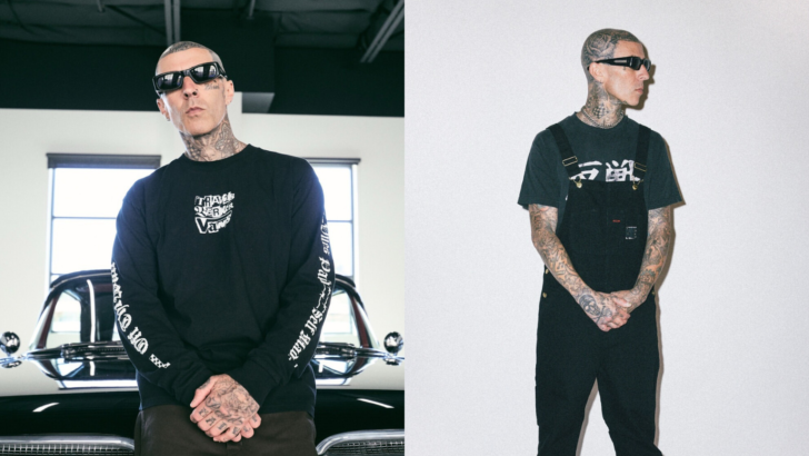 Homem tatuado usando óculos escuros e roupa preta posa em frente a um carro