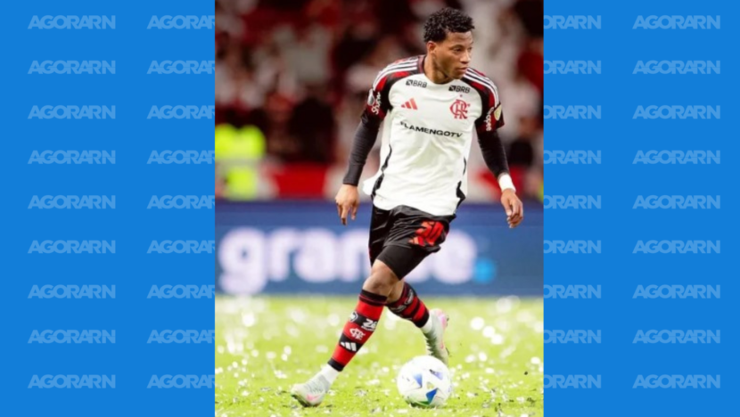Jogador com uniforme do Flamengo conduz a bola no gramado durante uma partida