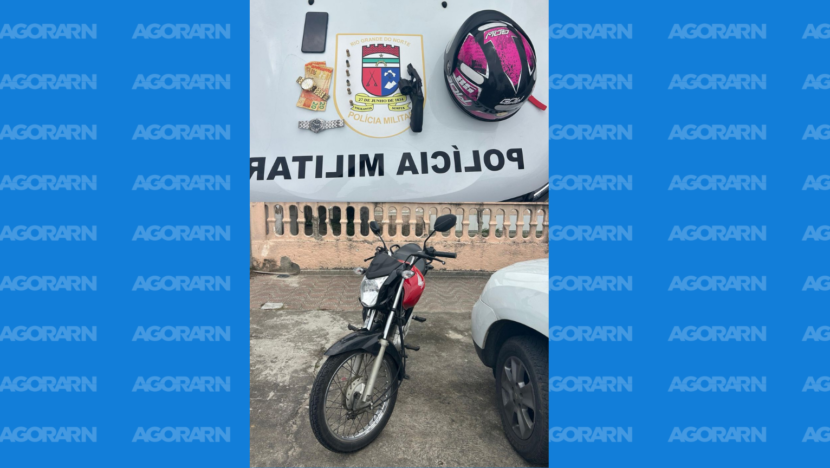 Motocicleta, revólver, munições, relógios, celular, dinheiro e capacete aparecem junto a veículo da Polícia Militar