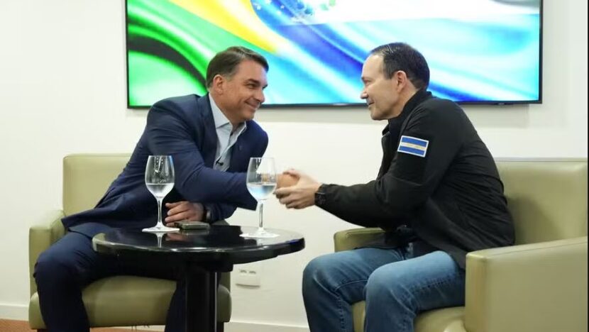 Flávio Bolsonaro ao lado do ministro salvadorenho Gustavo Villatoro em reunião em um hotel