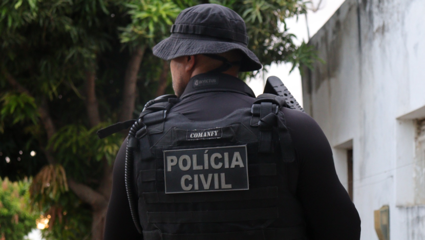 Policial Civil de costas com arma em mãos - Foto: PCRN