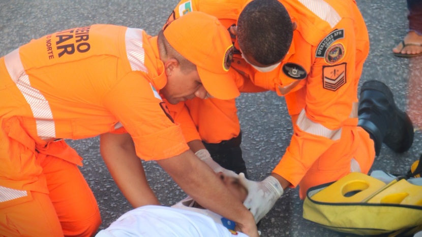 Imagem mostra dOis bombeiros atendendo homem caído após acidente - Foto: CBMRN