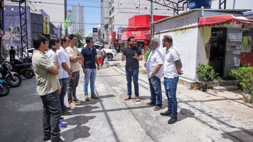Grupo de homens acompanha obras de recuperação do pavimento em rua comercial de Natal